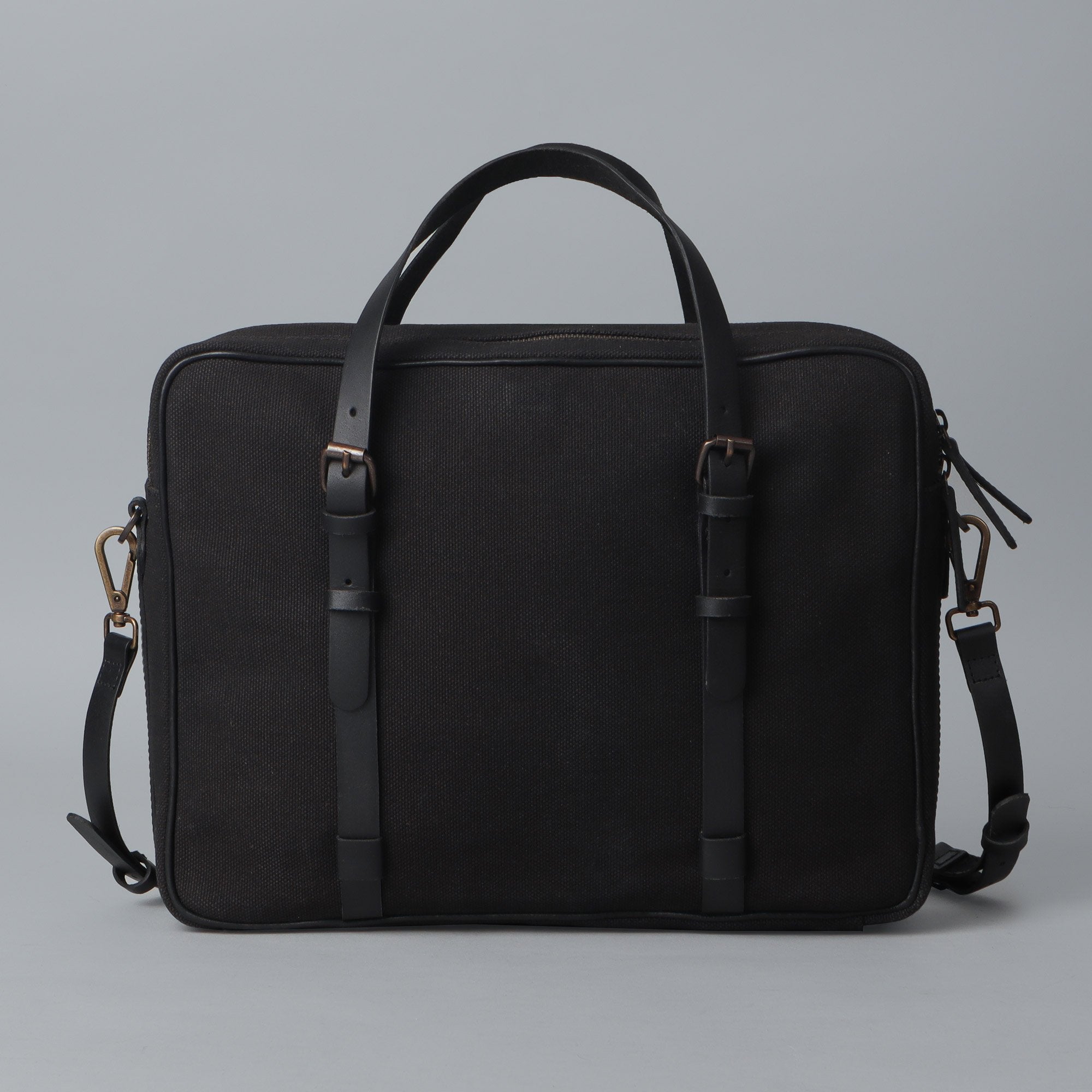 Miami Canvas Briefcase featuring durable cotton canvas, leather straps, and spacious compartments for laptops and essentials.