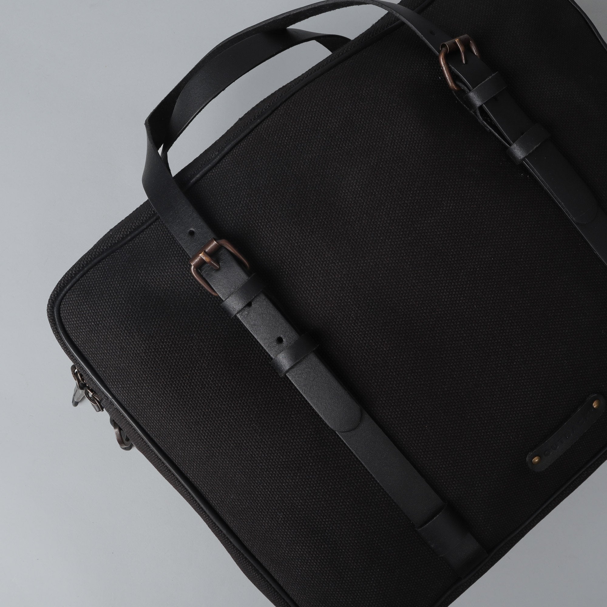 Miami Canvas Briefcase featuring durable cotton canvas, leather straps, and spacious compartments for laptops and essentials.