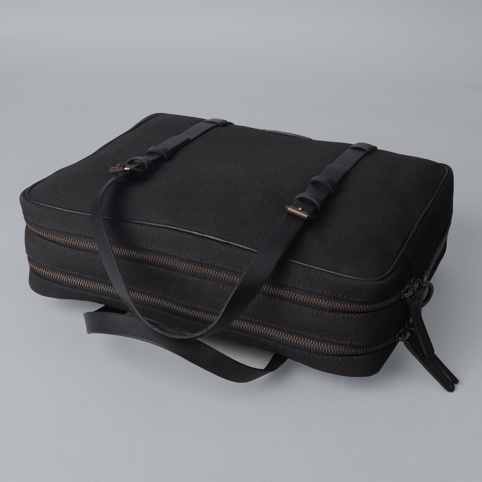 Miami Canvas Briefcase featuring durable cotton canvas, leather straps, and spacious compartments for laptops and essentials.