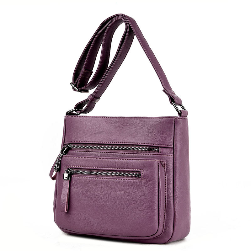 A stylish middle-aged women's soft leather shoulder bag in a box shape, featuring a zipper closure and trendy belt decoration, perfect for everyday use.