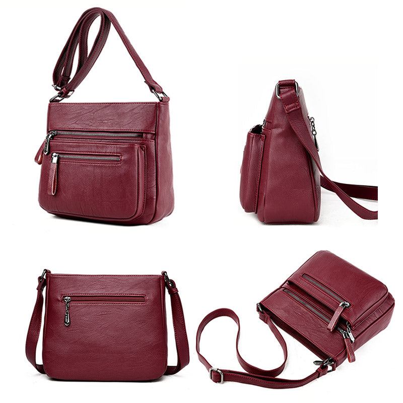 A stylish middle-aged women's soft leather shoulder bag in a box shape, featuring a zipper closure and trendy belt decoration, perfect for everyday use.