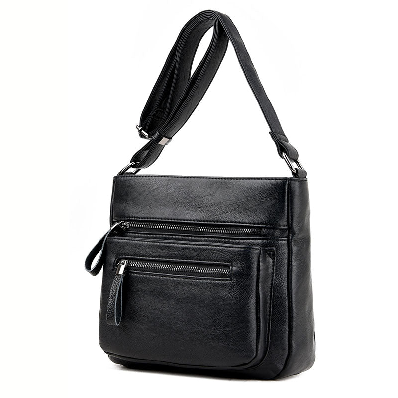 A stylish middle-aged women's soft leather shoulder bag in a box shape, featuring a zipper closure and trendy belt decoration, perfect for everyday use.