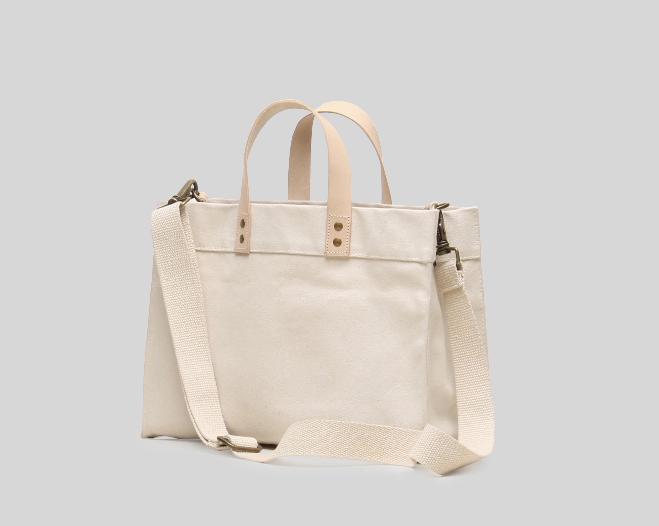 Mini Box Tote Bag featuring heavyweight canvas, thick leather handle, and metal studs for a high-end look.