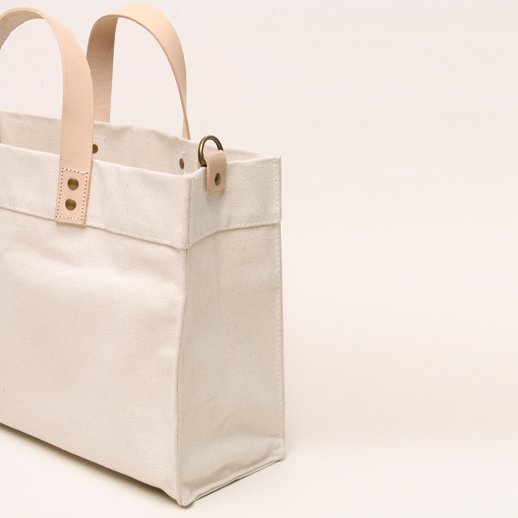 Mini Box Tote Bag featuring heavyweight canvas, thick leather handle, and metal studs for a high-end look.