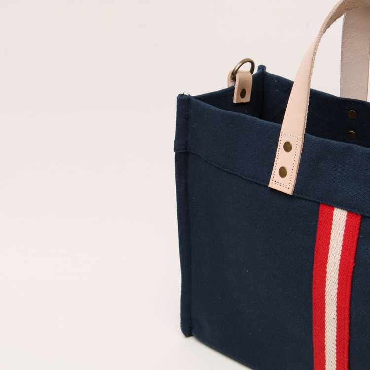 Mini Box Tote Bag featuring heavyweight canvas, thick leather handle, and metal studs for a high-end look.