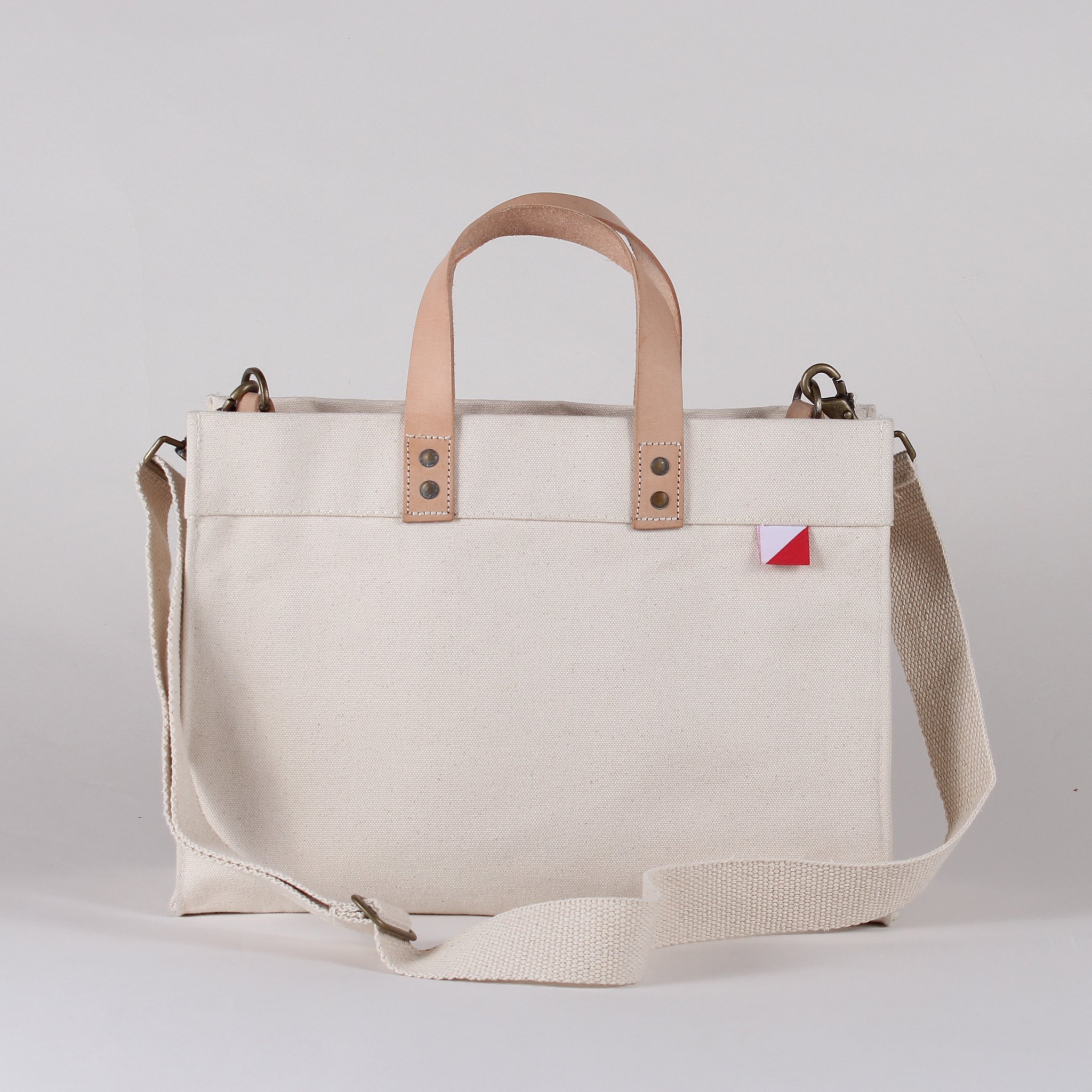 Mini Box Tote Bag featuring heavyweight canvas, thick leather handle, and metal studs for a high-end look.