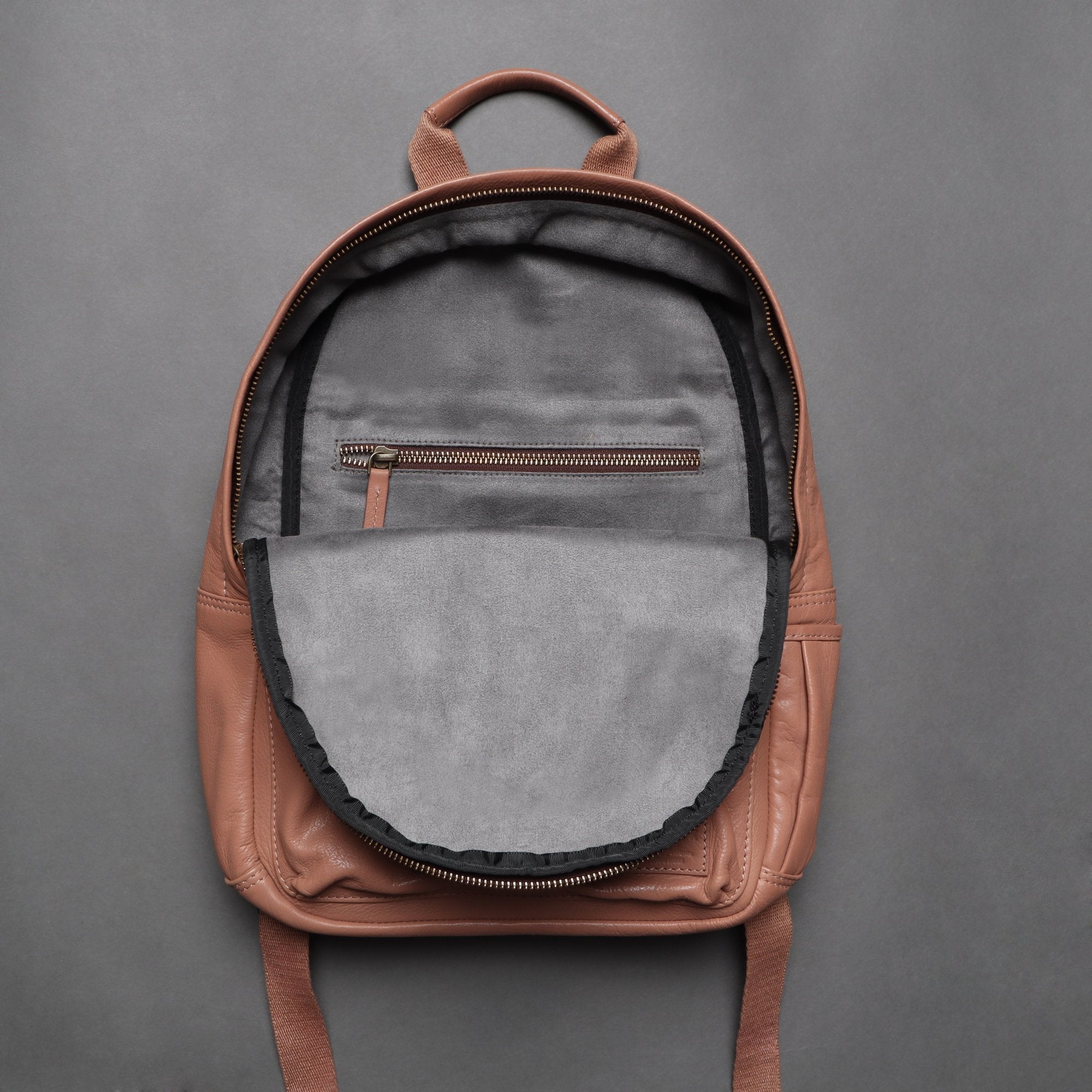 Mini Journey Leather Backpack made from premium full grain leather, featuring adjustable straps and multiple pockets for convenience.