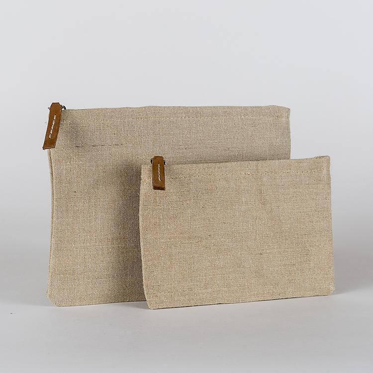 A set of two modern jute pouches with striped cotton lining and leather pulls, showcasing their elegant design and eco-friendly material.