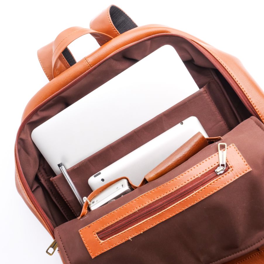 Tan brown On-The-Go Leather Backpack showcasing its sleek design and multiple compartments.