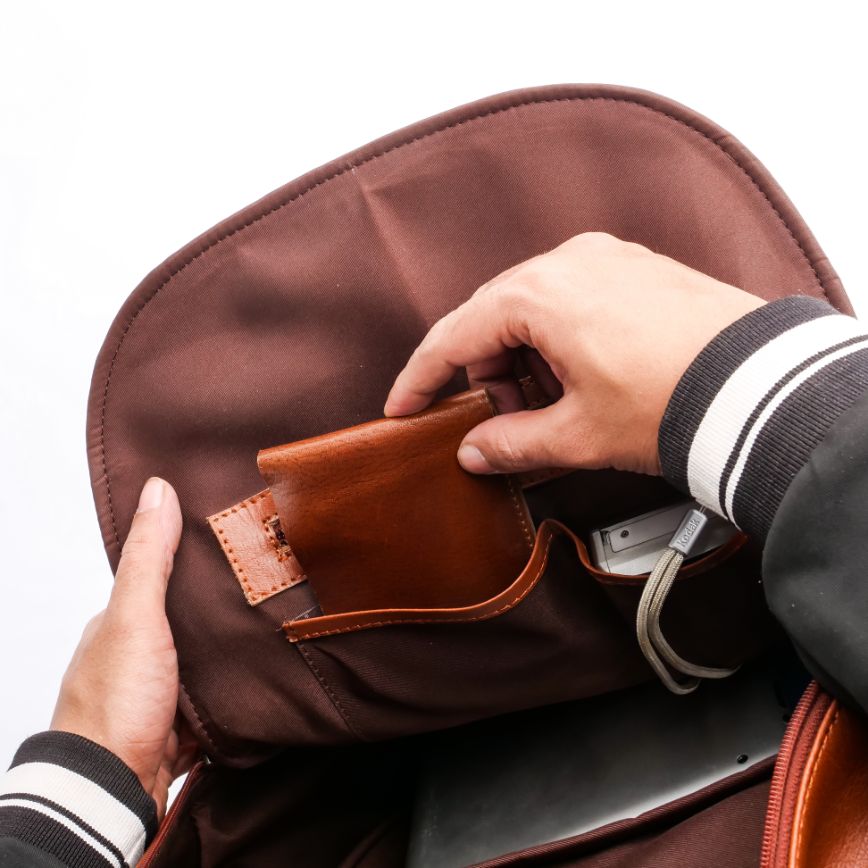 Tan brown On-The-Go Leather Backpack showcasing its sleek design and multiple compartments.