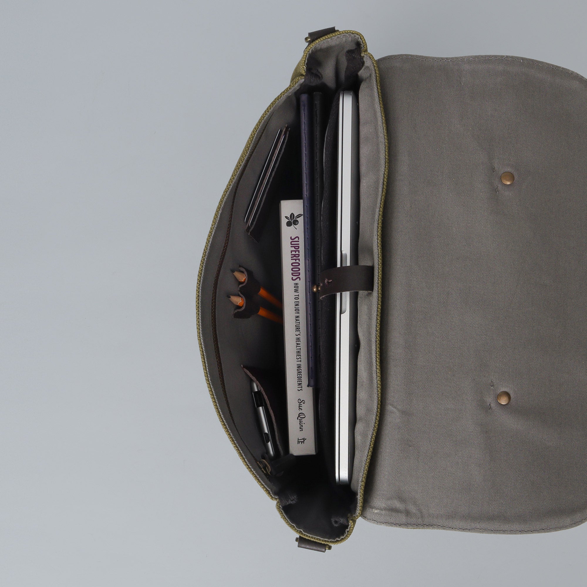 Oslo Canvas Briefcase made from durable cotton canvas, featuring leather straps and multiple pockets for organization, suitable for laptops up to 13 inches.