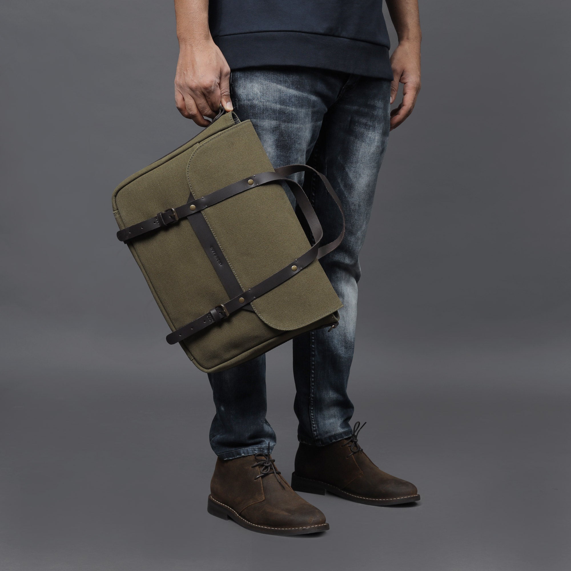 Oslo Canvas Briefcase made from durable cotton canvas, featuring leather straps and multiple pockets for organization, suitable for laptops up to 13 inches.