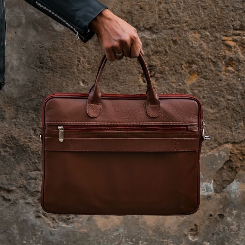 Parker Slim Leather Laptop Bag in Tan, showcasing its sleek design, adjustable shoulder strap, and multiple compartments for organization.