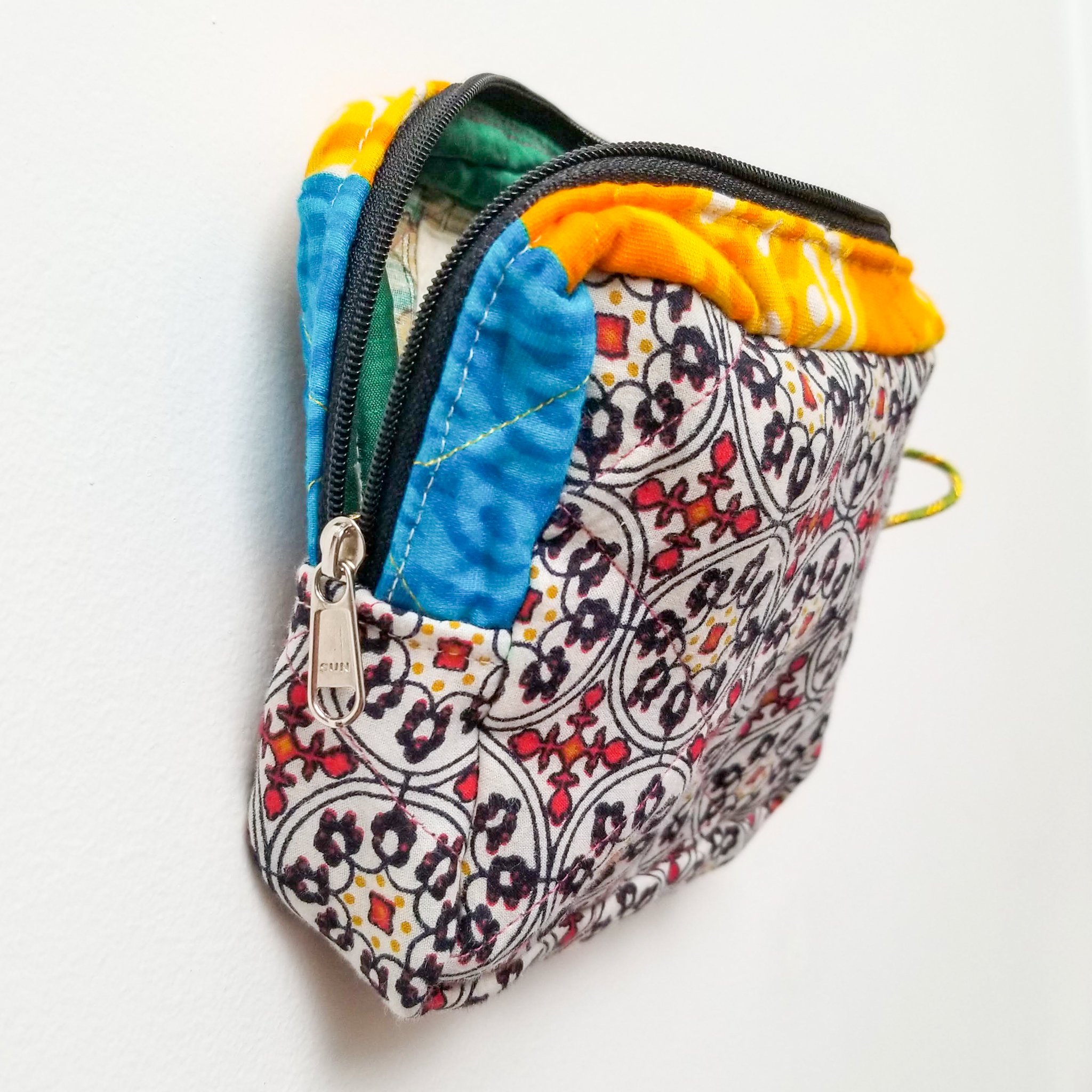 Colorful patchwork sari box pouch handcrafted by artisans in India, showcasing unique patterns and vibrant colors.