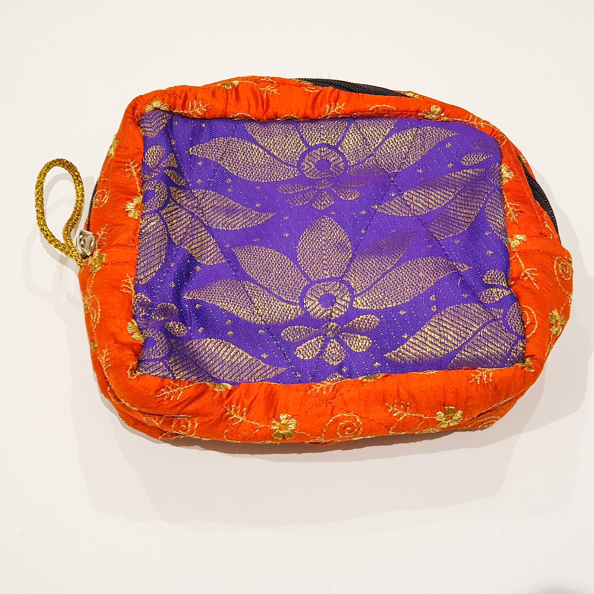 Colorful patchwork sari box pouch handcrafted by artisans in India, showcasing unique patterns and vibrant colors.