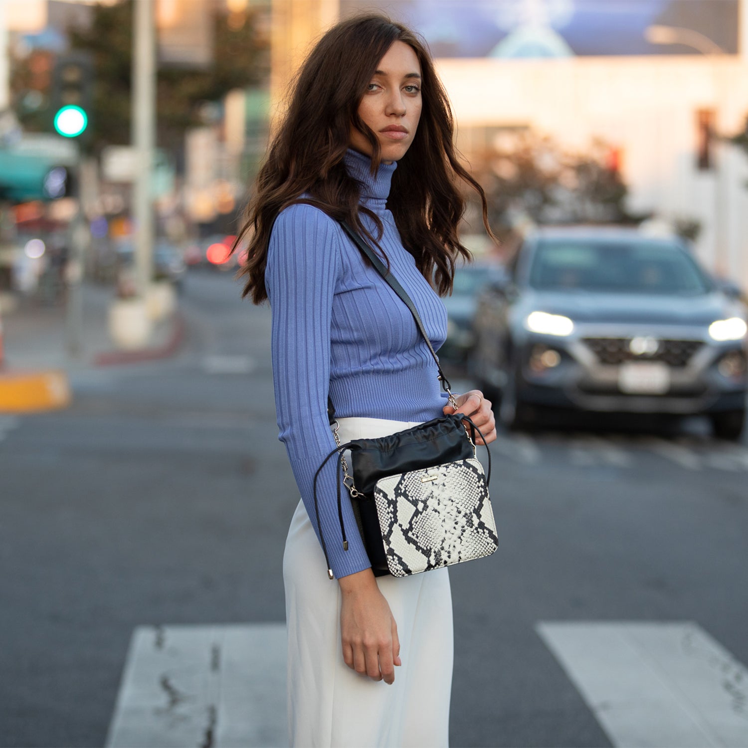 Patricia Black Leather Bucket Bag featuring a unique snakeskin design with gold hardware and teal interior.