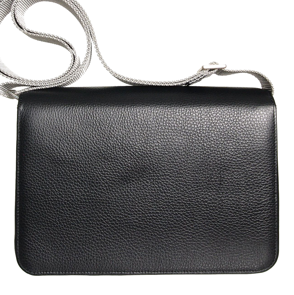 A stylish black pebbled leather crossbody bag with a contrasting vinyl strap, featuring a magnetic flap closure and handmade craftsmanship from Milan, Italy.