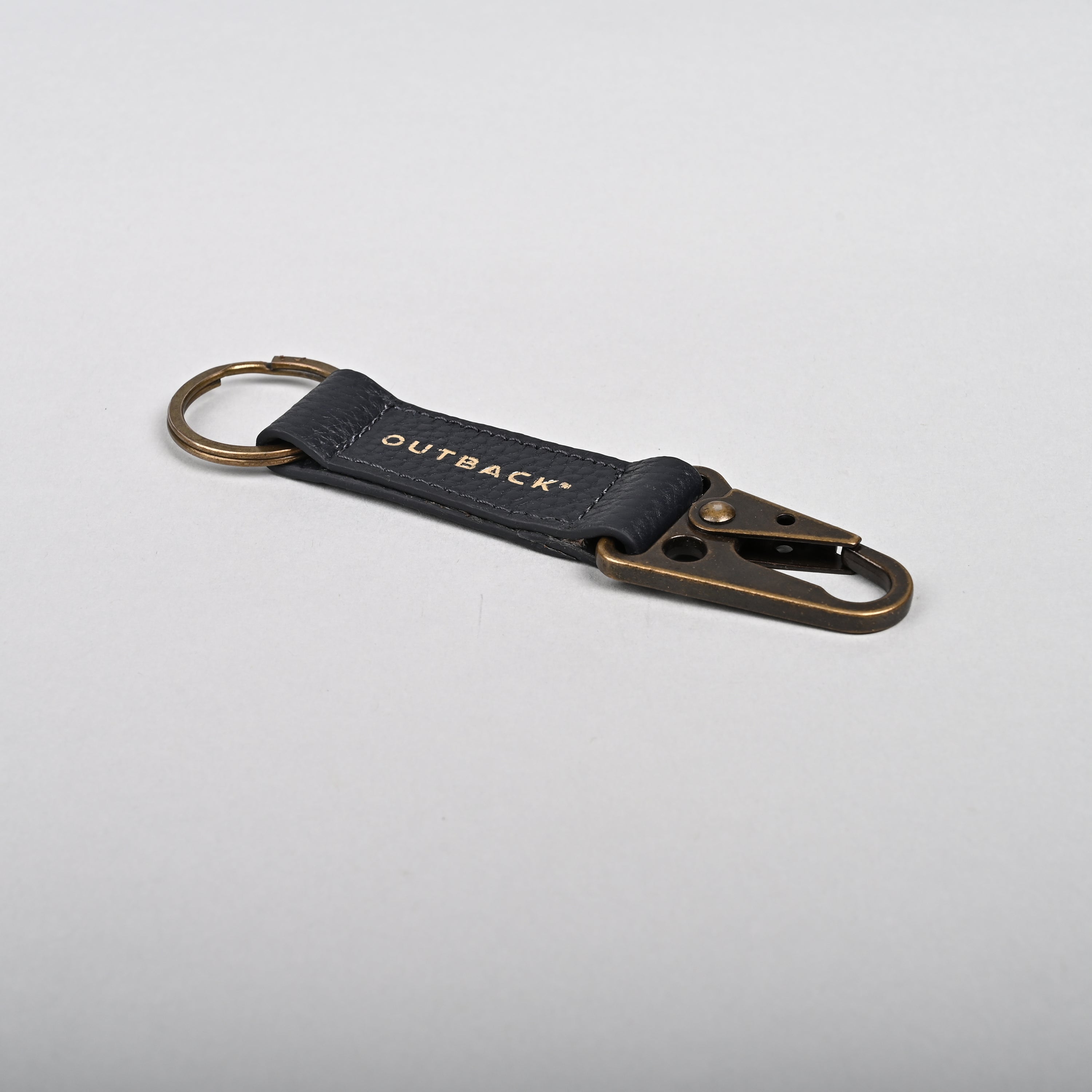 Performance Key Holder made from premium leather with antique brass hardware, showcasing its elegant design and snap hook mechanism.