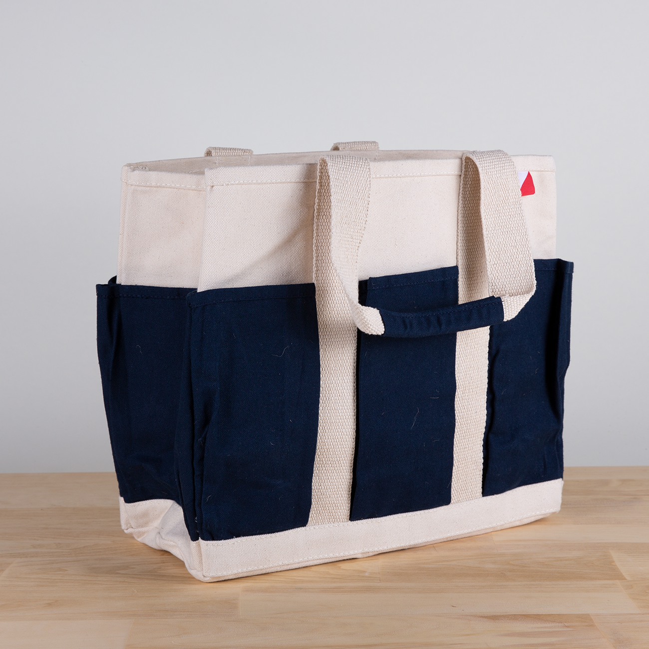 A medium-sized Pocket Tote made from heavy-duty recycled cotton canvas, featuring eight external gusseted pockets for organization.