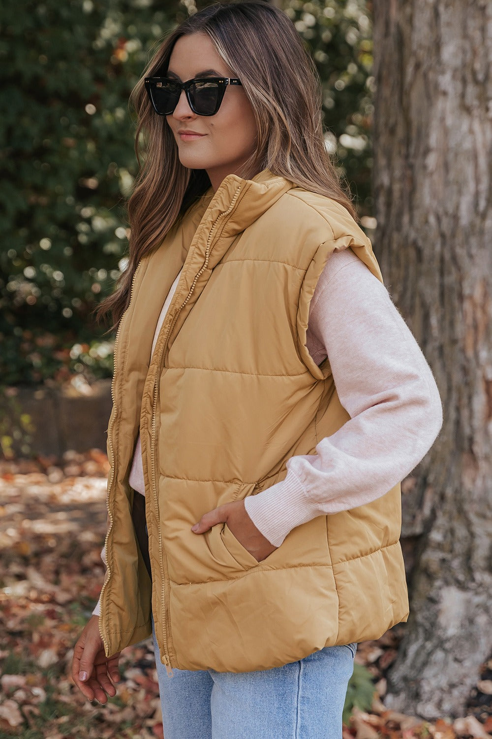 A stylish Pocketed Zip Up Vest Coat in a neutral color, featuring a zip closure and pockets, perfect for layering in various outfits.