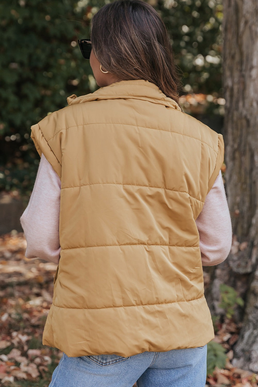 A stylish Pocketed Zip Up Vest Coat in a neutral color, featuring a zip closure and pockets, perfect for layering in various outfits.