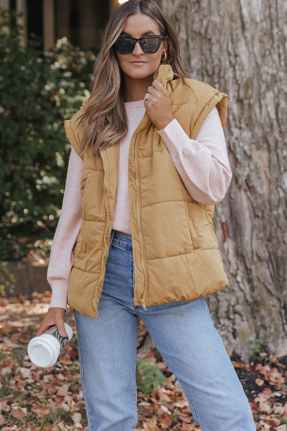 A stylish Pocketed Zip Up Vest Coat in a neutral color, featuring a zip closure and pockets, perfect for layering in various outfits.