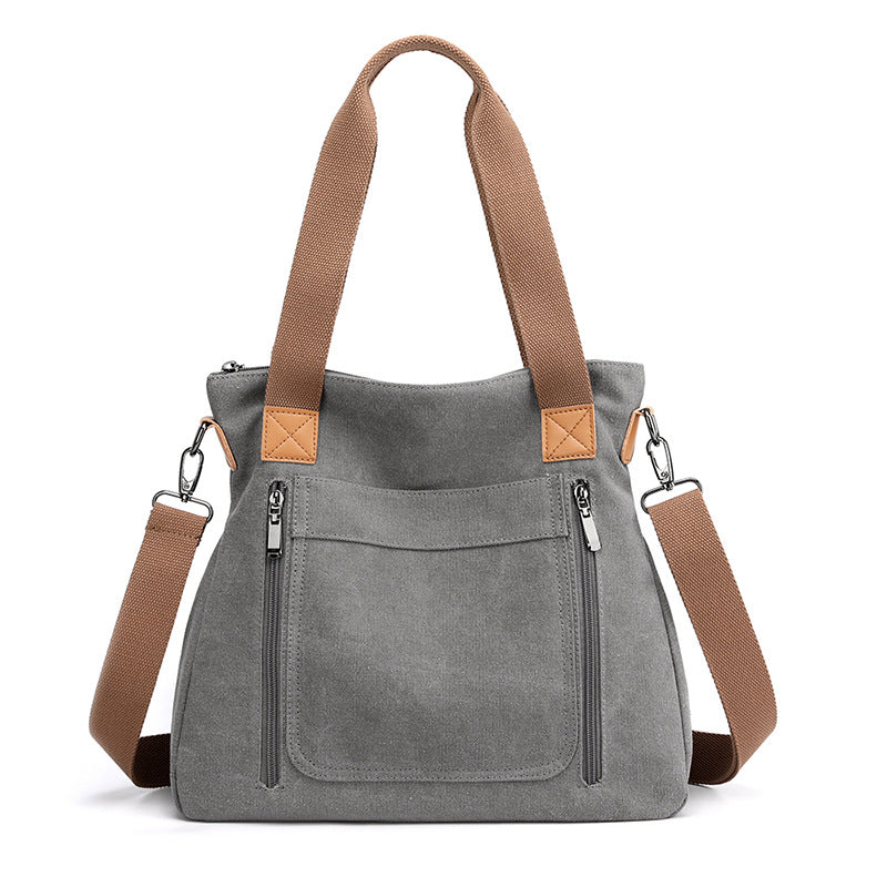 A stylish portable large-capacity female casual canvas shoulder bag in a horizontal square shape, featuring a zipper closure and soft handle.