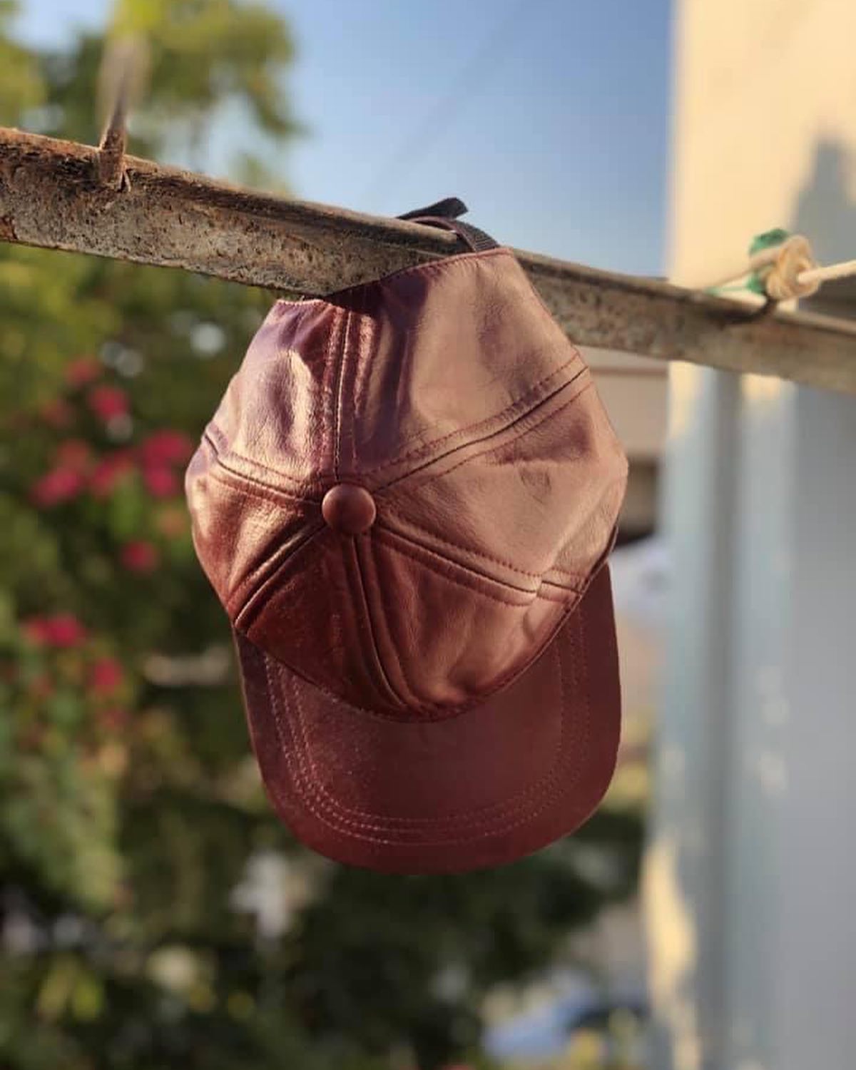 Brown pure leather cap with adjustable clip, showcasing its durable material and stylish design.