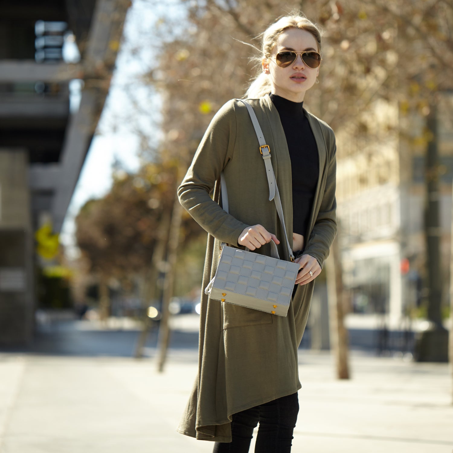 Stylish quilted gray leather purse with rose gold studs and adjustable strap, showcasing its elegant design and spacious compartments.