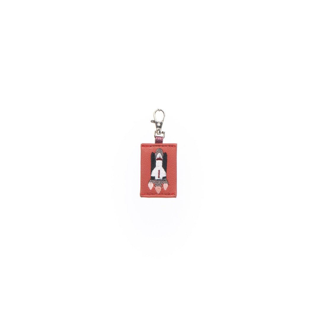 A colorful Rocket Charm made from vegan leather, designed as a keychain or bag decoration.