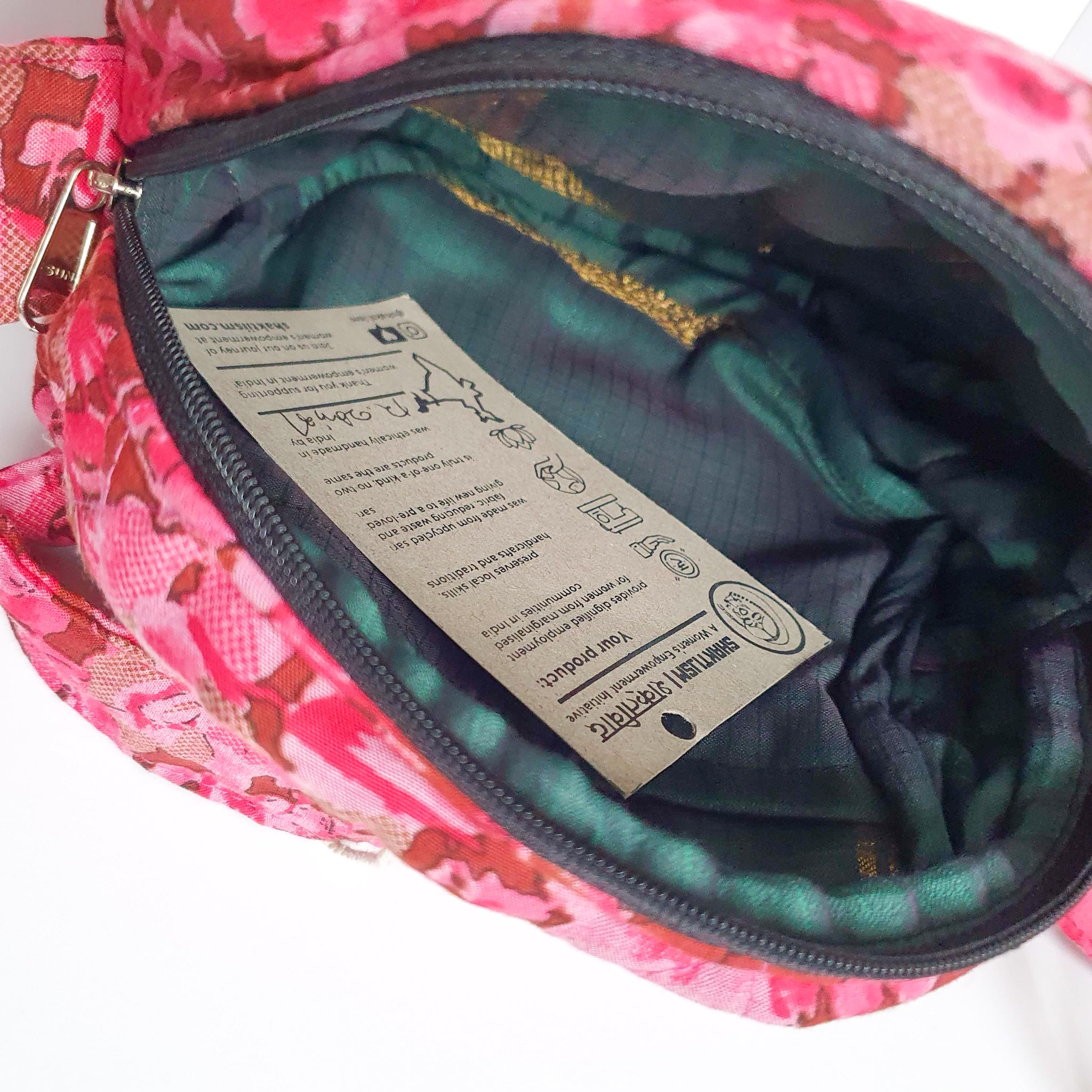 A vibrant round shoulder bag made from repurposed saris, showcasing unique patterns and colors, handcrafted by artisans in India.