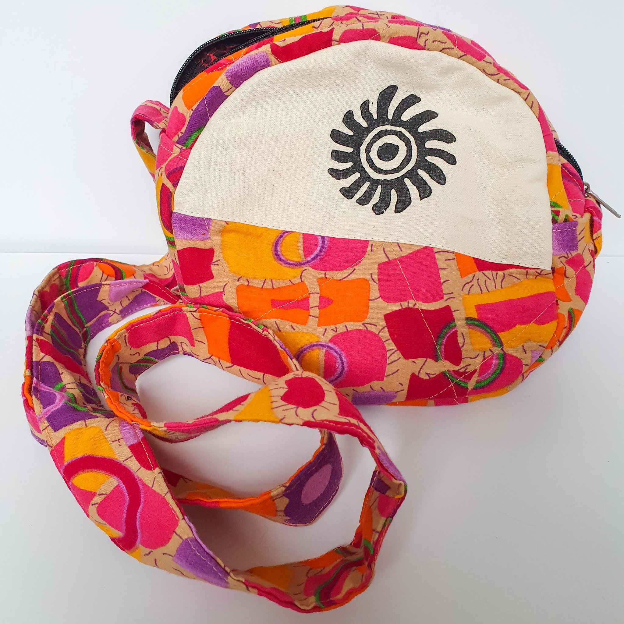 A vibrant round shoulder bag made from repurposed saris, showcasing unique patterns and colors, handcrafted by artisans in India.