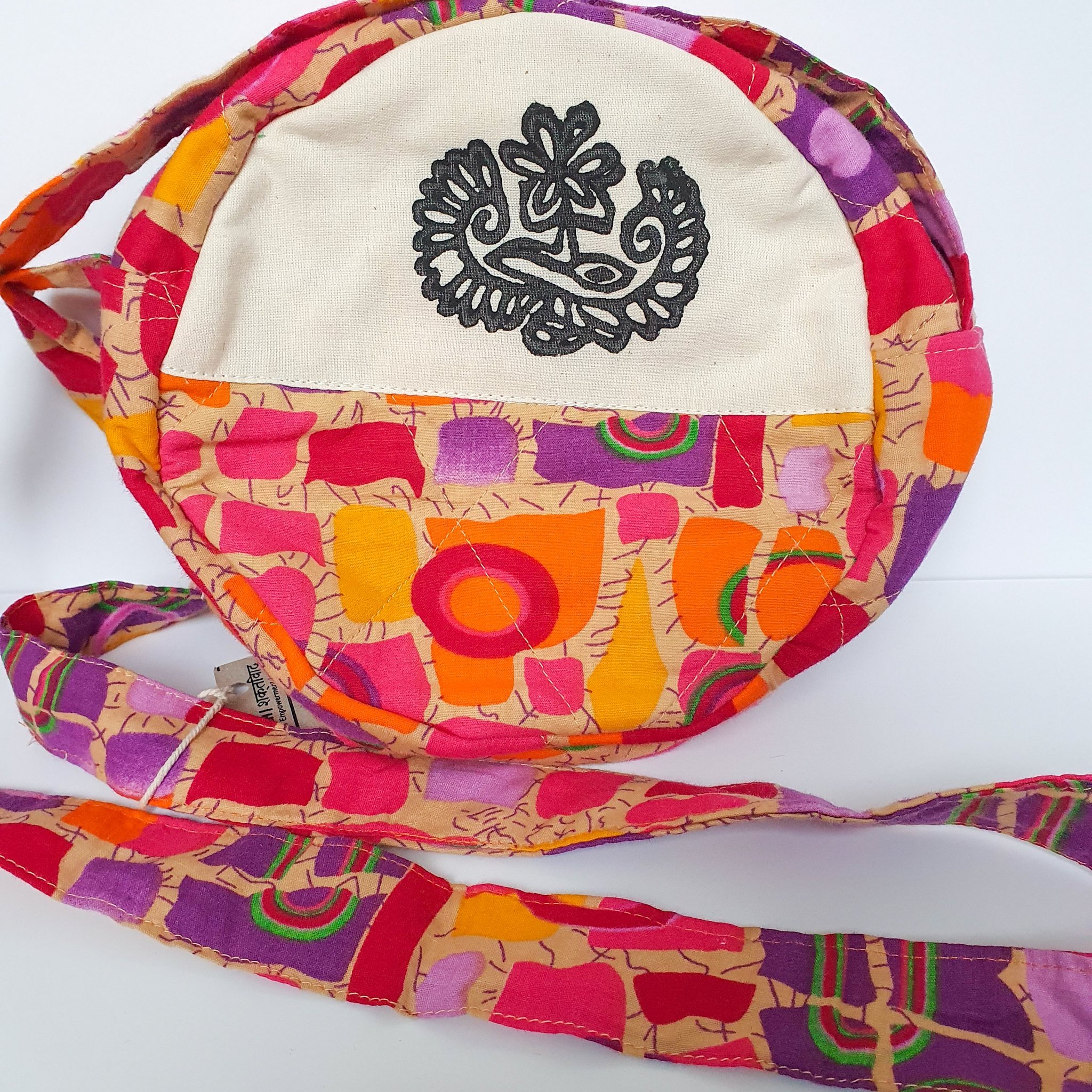 A vibrant round shoulder bag made from repurposed saris, showcasing unique patterns and colors, handcrafted by artisans in India.