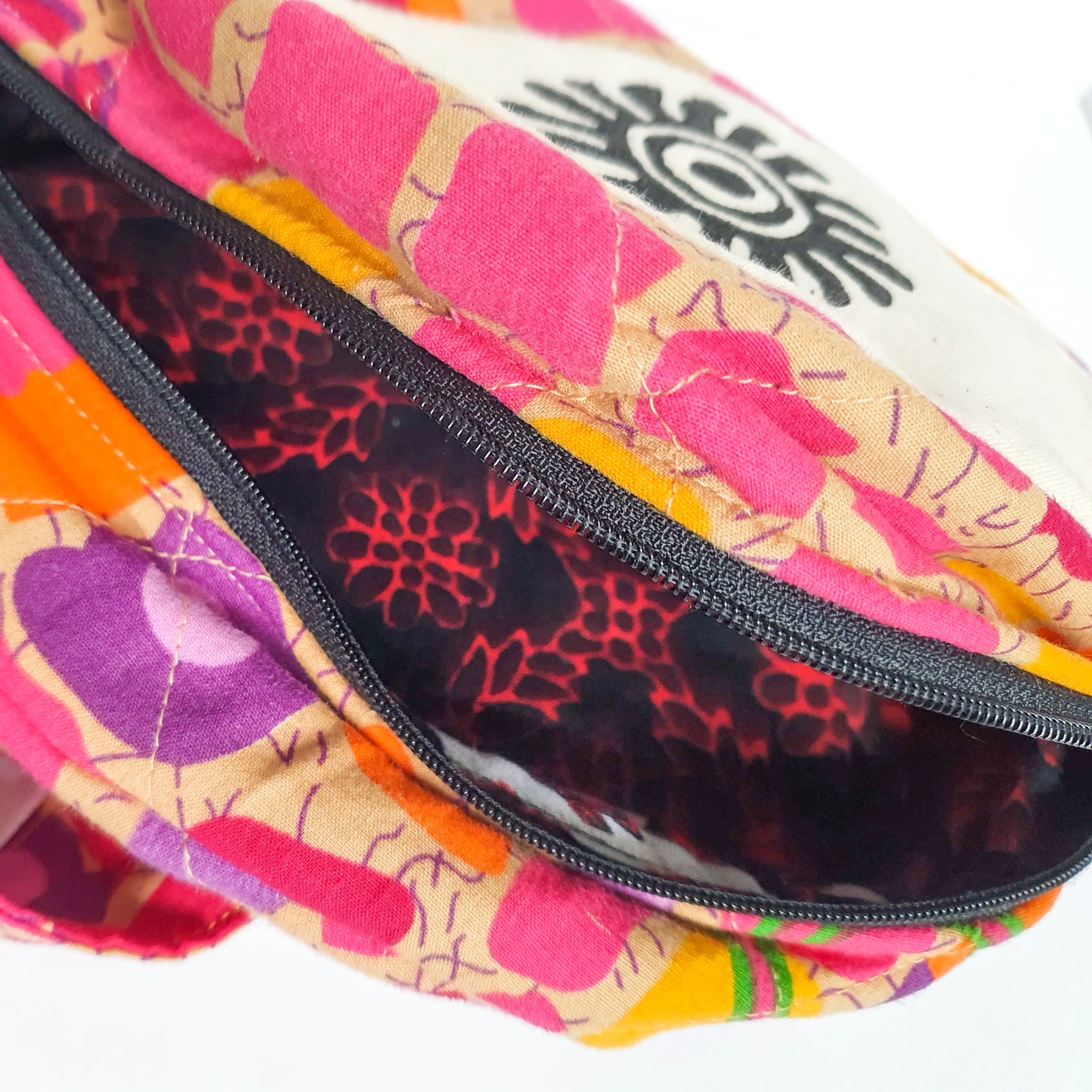 A vibrant round shoulder bag made from repurposed saris, showcasing unique patterns and colors, handcrafted by artisans in India.