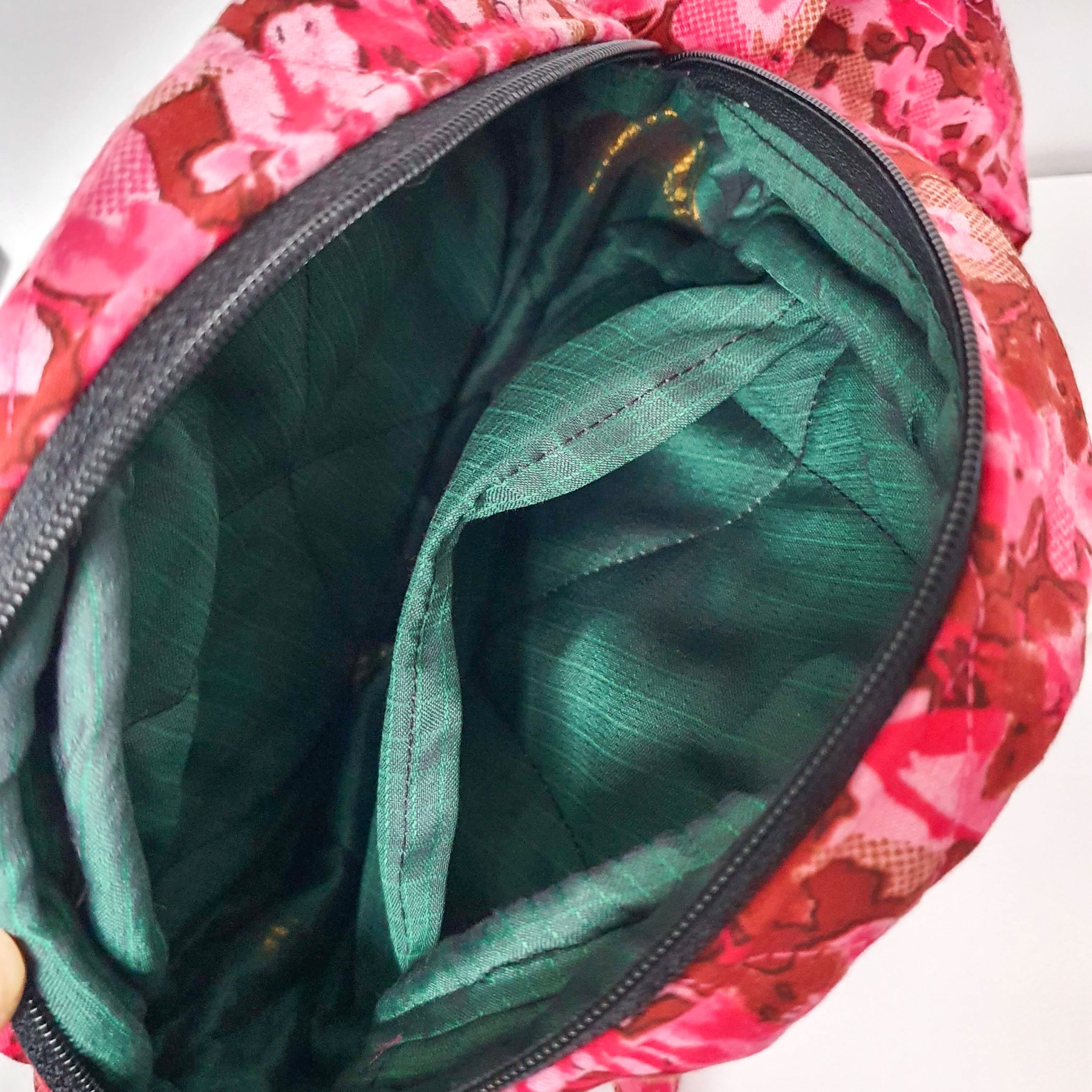 A vibrant round shoulder bag made from repurposed saris, showcasing unique patterns and colors, handcrafted by artisans in India.