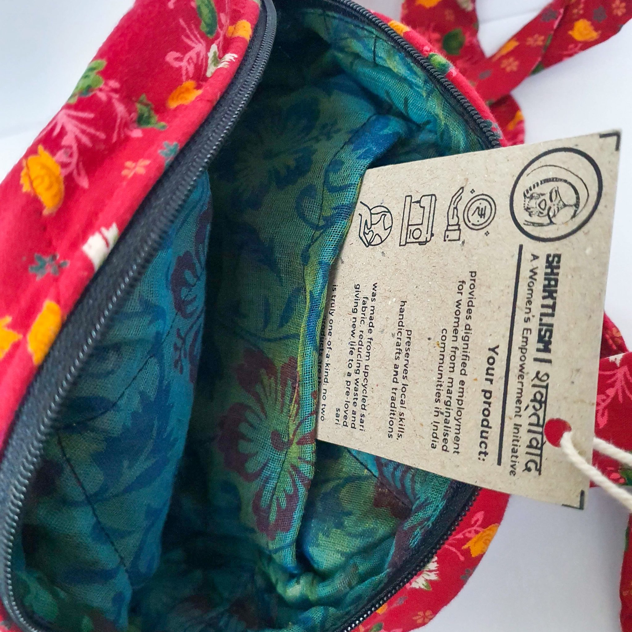 A vibrant round shoulder bag made from repurposed saris, showcasing unique patterns and colors, handcrafted by artisans in India.