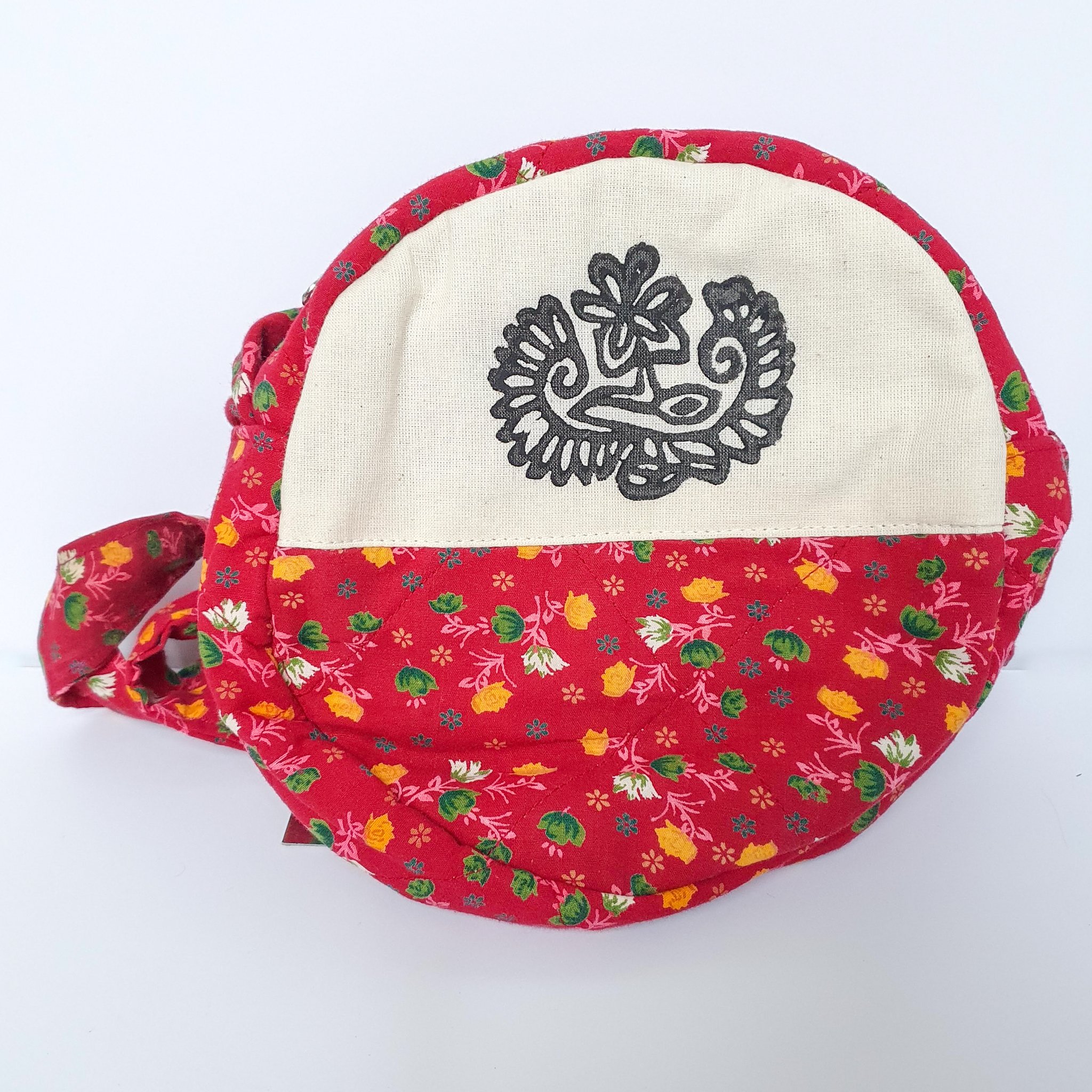 A vibrant round shoulder bag made from repurposed saris, showcasing unique patterns and colors, handcrafted by artisans in India.