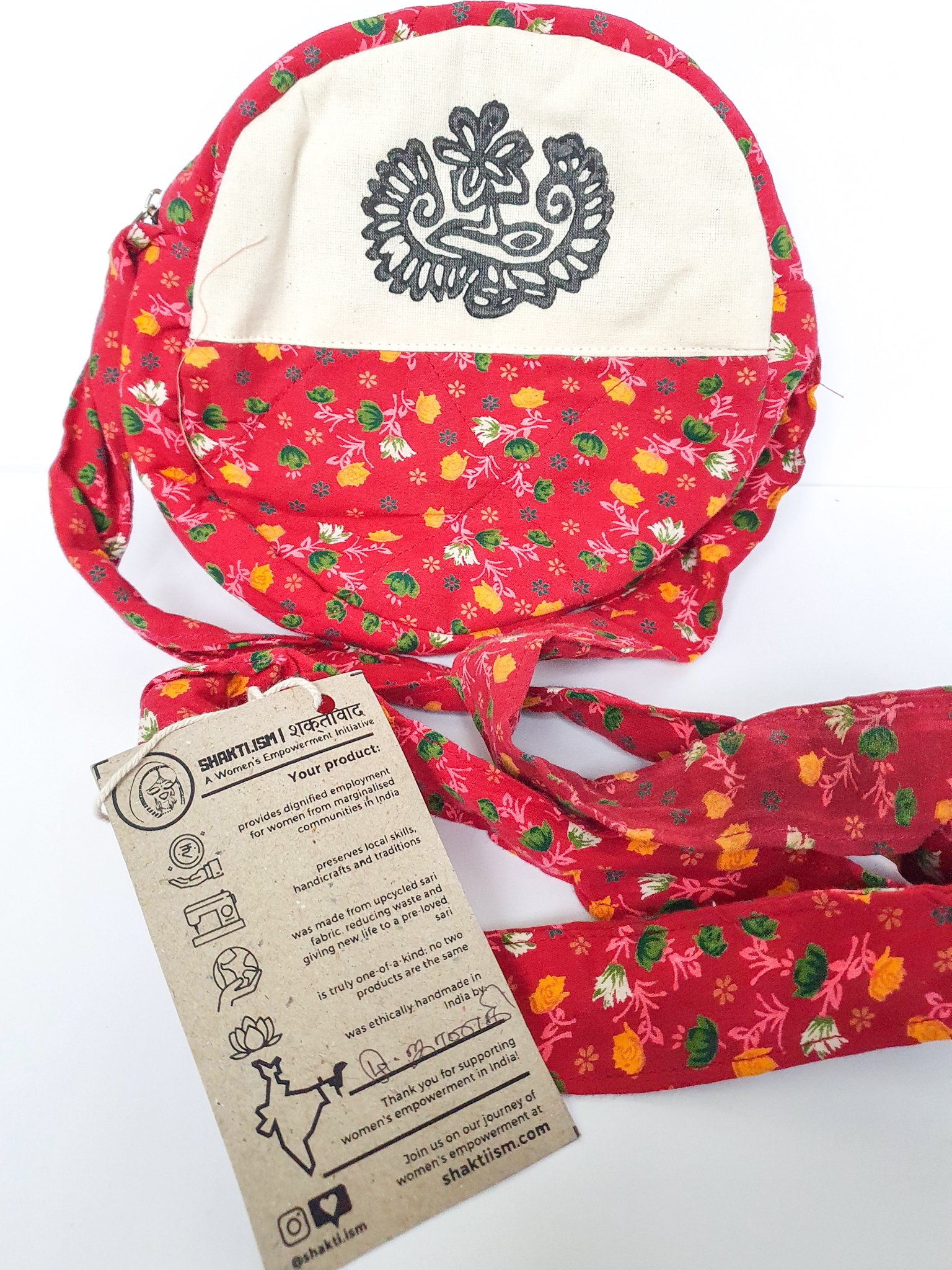 A vibrant round shoulder bag made from repurposed saris, showcasing unique patterns and colors, handcrafted by artisans in India.