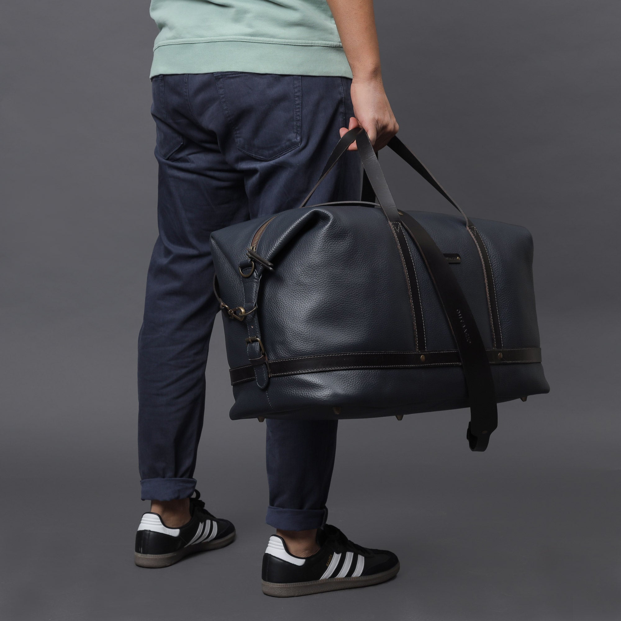 Runway Leather Travel Bag made from premium full grain leather, featuring vintage buckles and an adjustable shoulder strap.