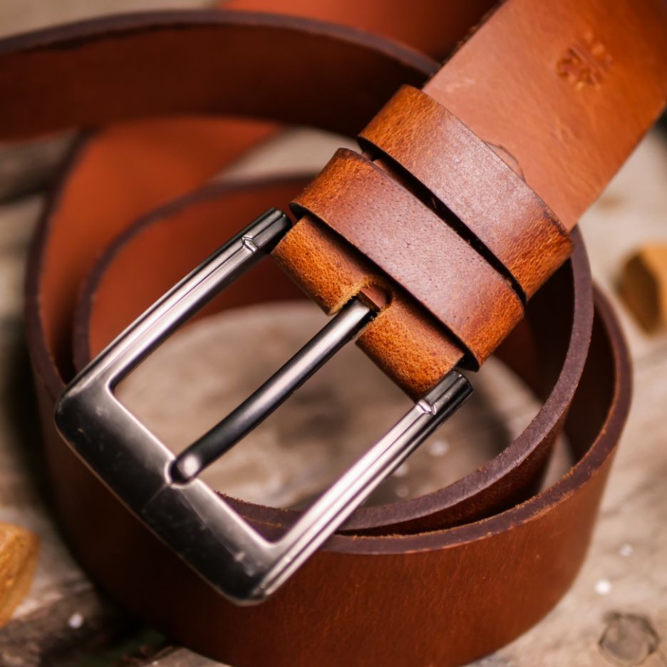 A rustic leather belt with double thread stitching and a single pin buckle, showcasing its quality and style.