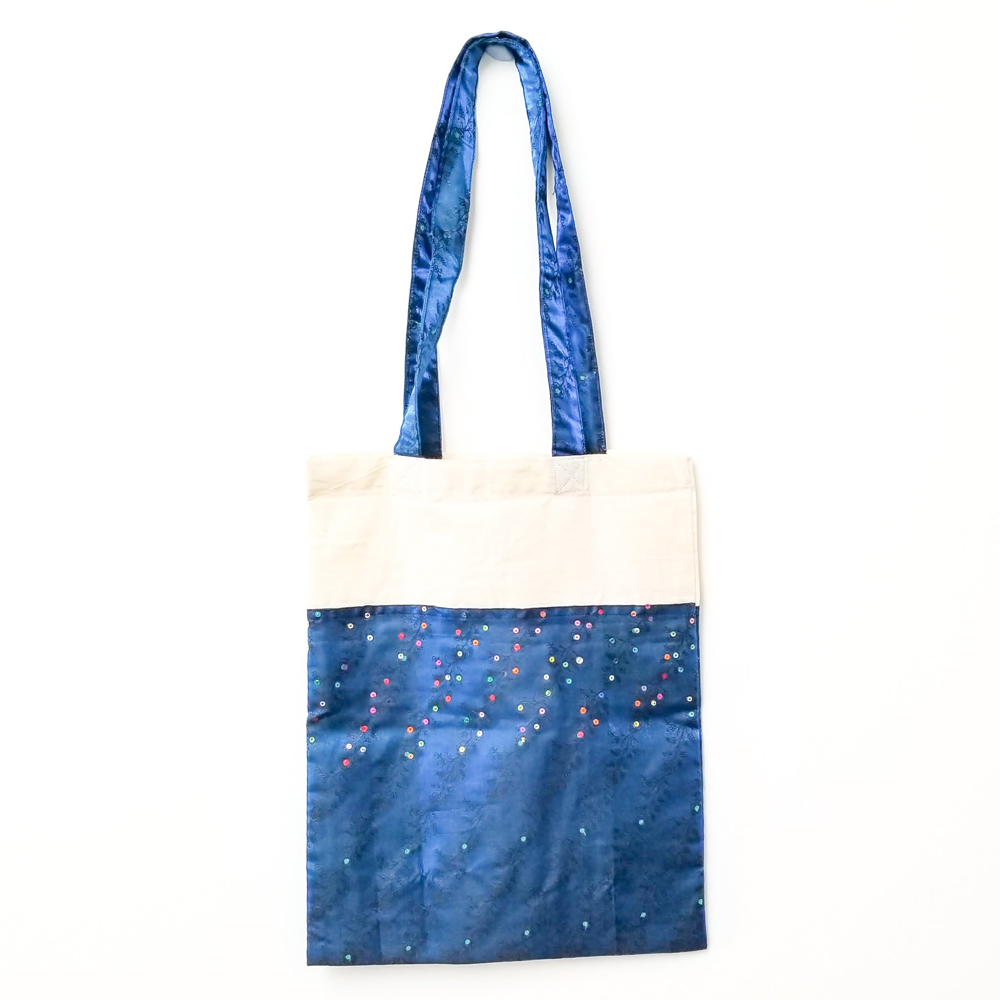 A vibrant Sari Tote Bag handcrafted from repurposed saris, showcasing unique patterns and colors, perfect for shopping and daily use.