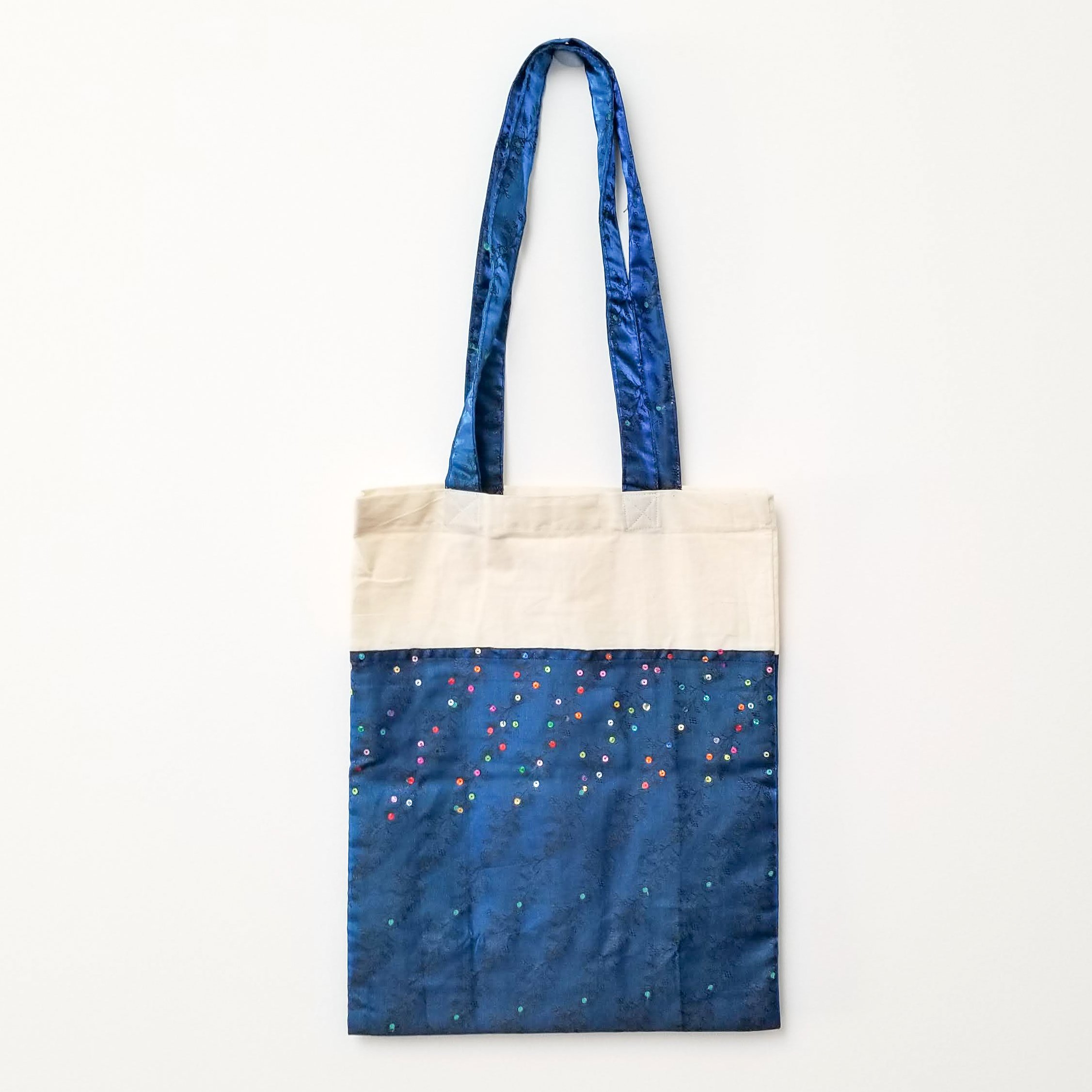 A vibrant Sari Tote Bag handcrafted from repurposed saris, showcasing unique patterns and colors, perfect for shopping and daily use.