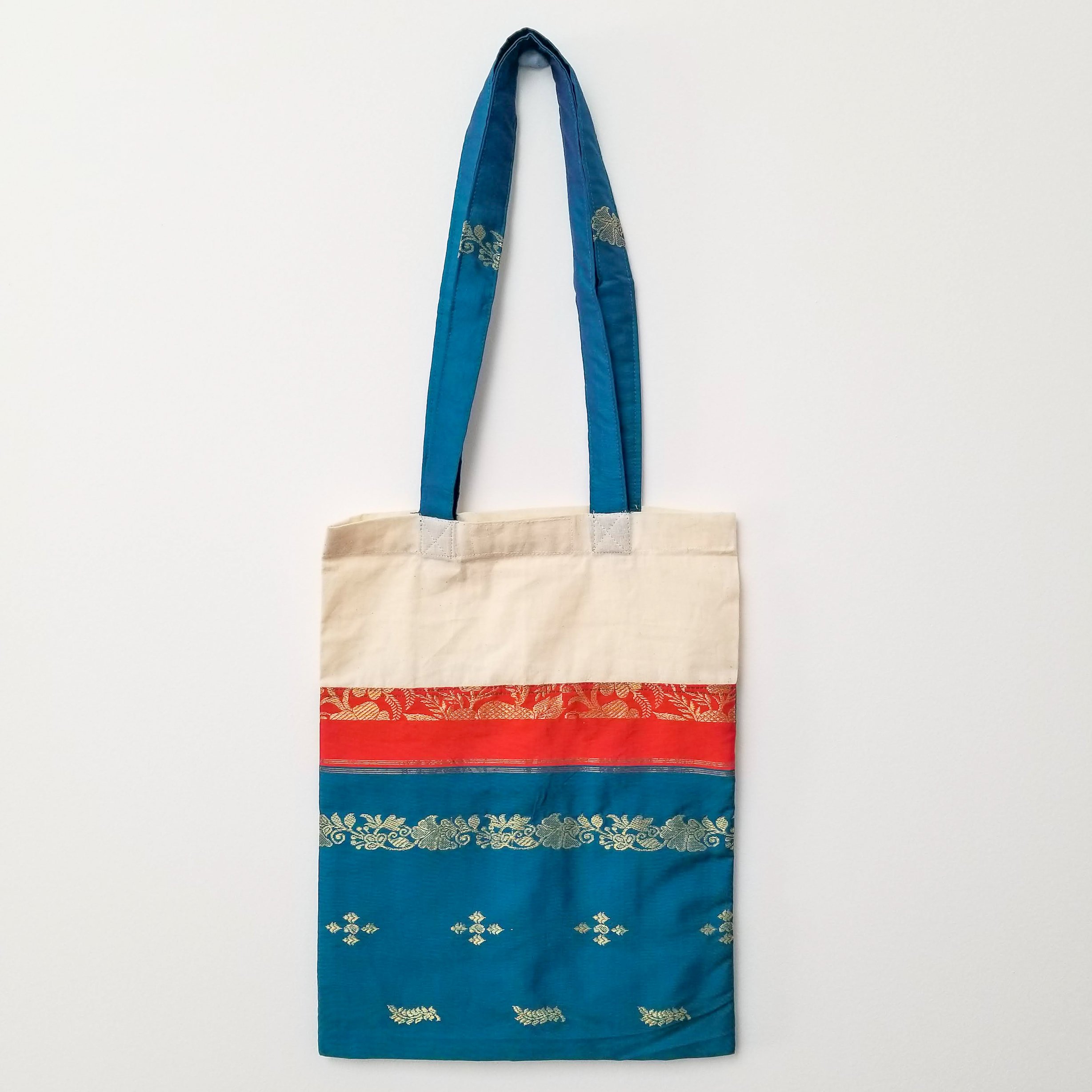 A vibrant Sari Tote Bag handcrafted from repurposed saris, showcasing unique patterns and colors, perfect for shopping and daily use.