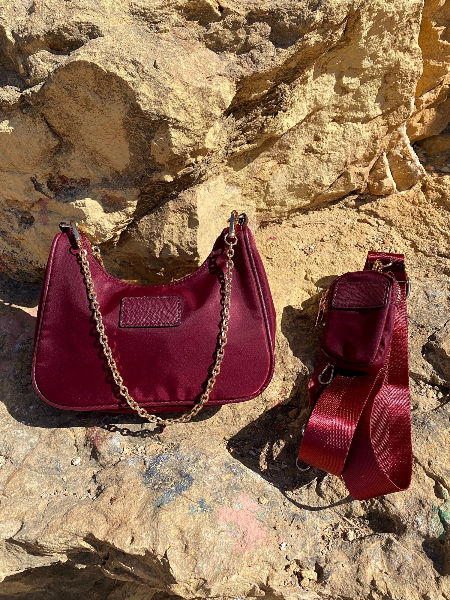 Stylish shoulder bag in magenta and beige with adjustable strap and zip closure, featuring a lined interior and zip pocket.