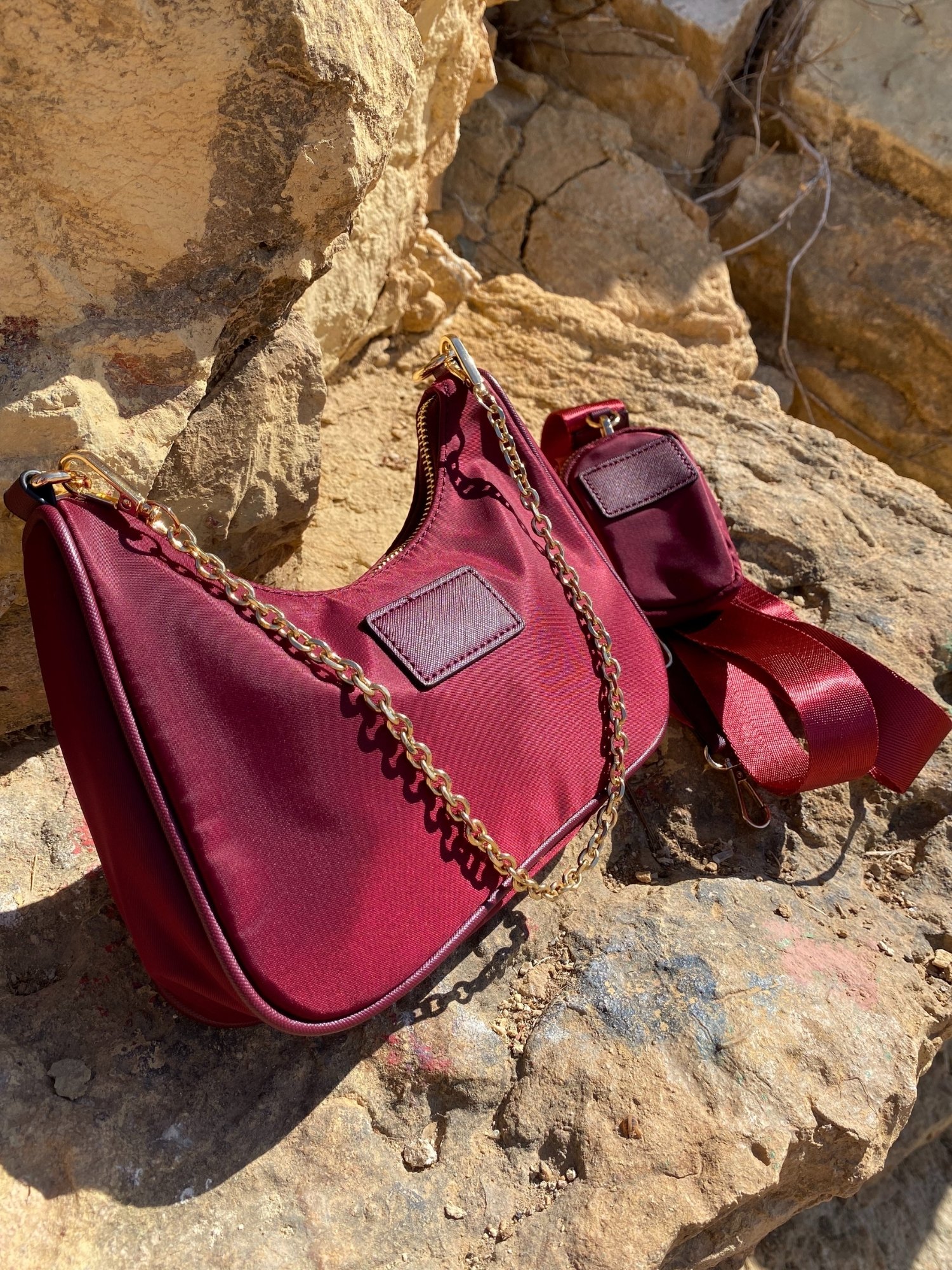 Stylish shoulder bag in magenta and beige with adjustable strap and zip closure, featuring a lined interior and zip pocket.