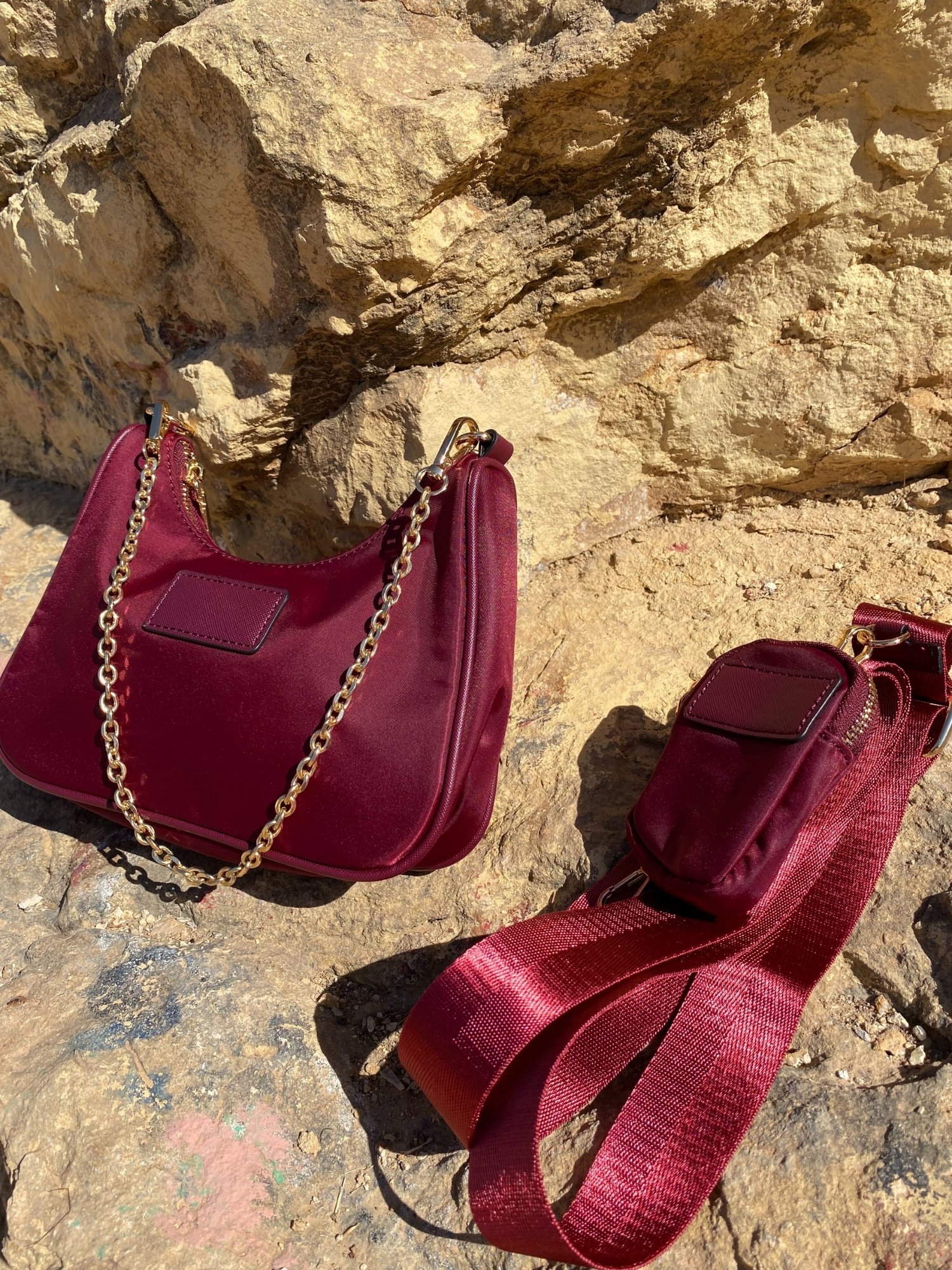 Stylish shoulder bag in magenta and beige with adjustable strap and zip closure, featuring a lined interior and zip pocket.