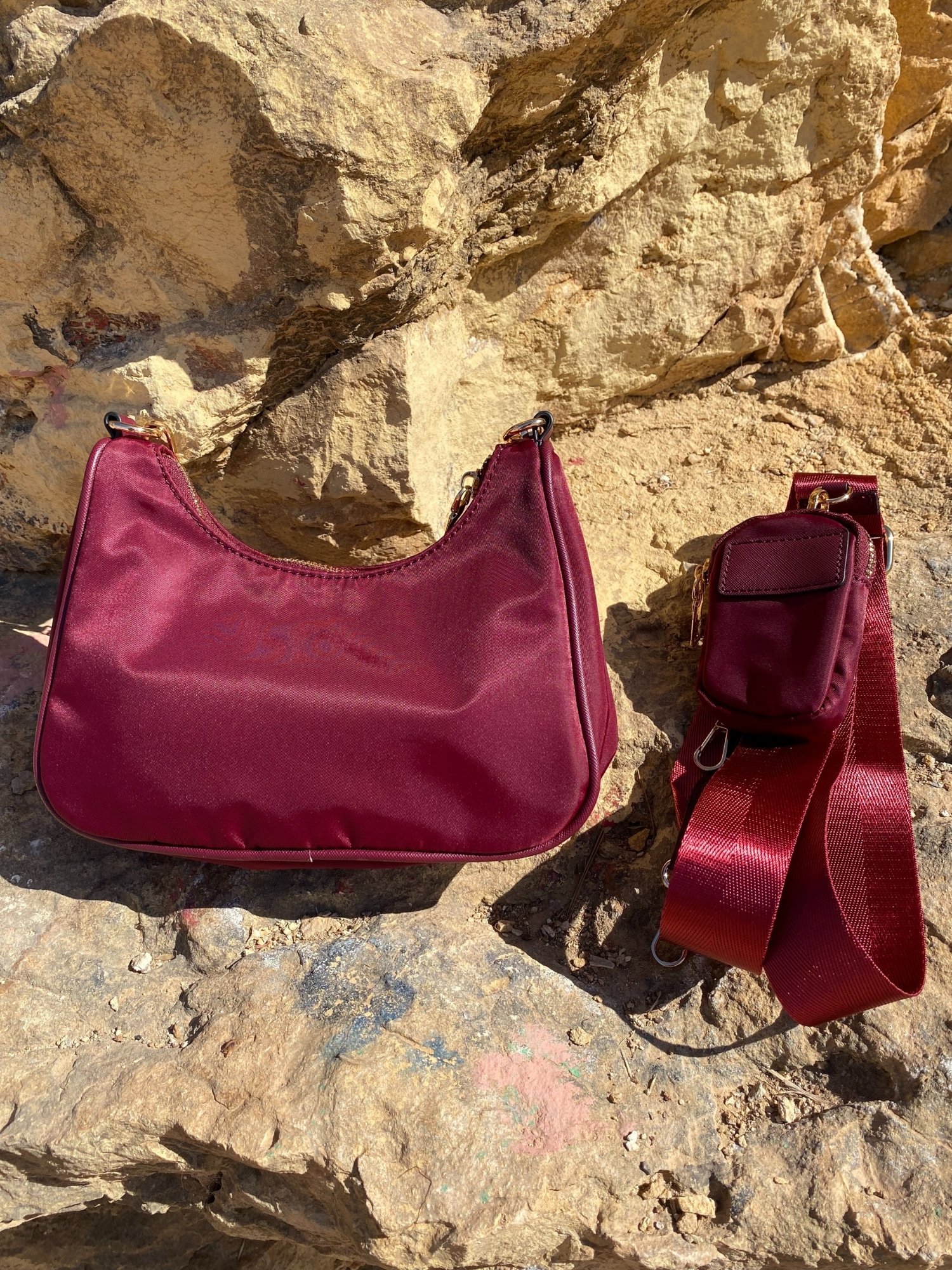 Stylish shoulder bag in magenta and beige with adjustable strap and zip closure, featuring a lined interior and zip pocket.