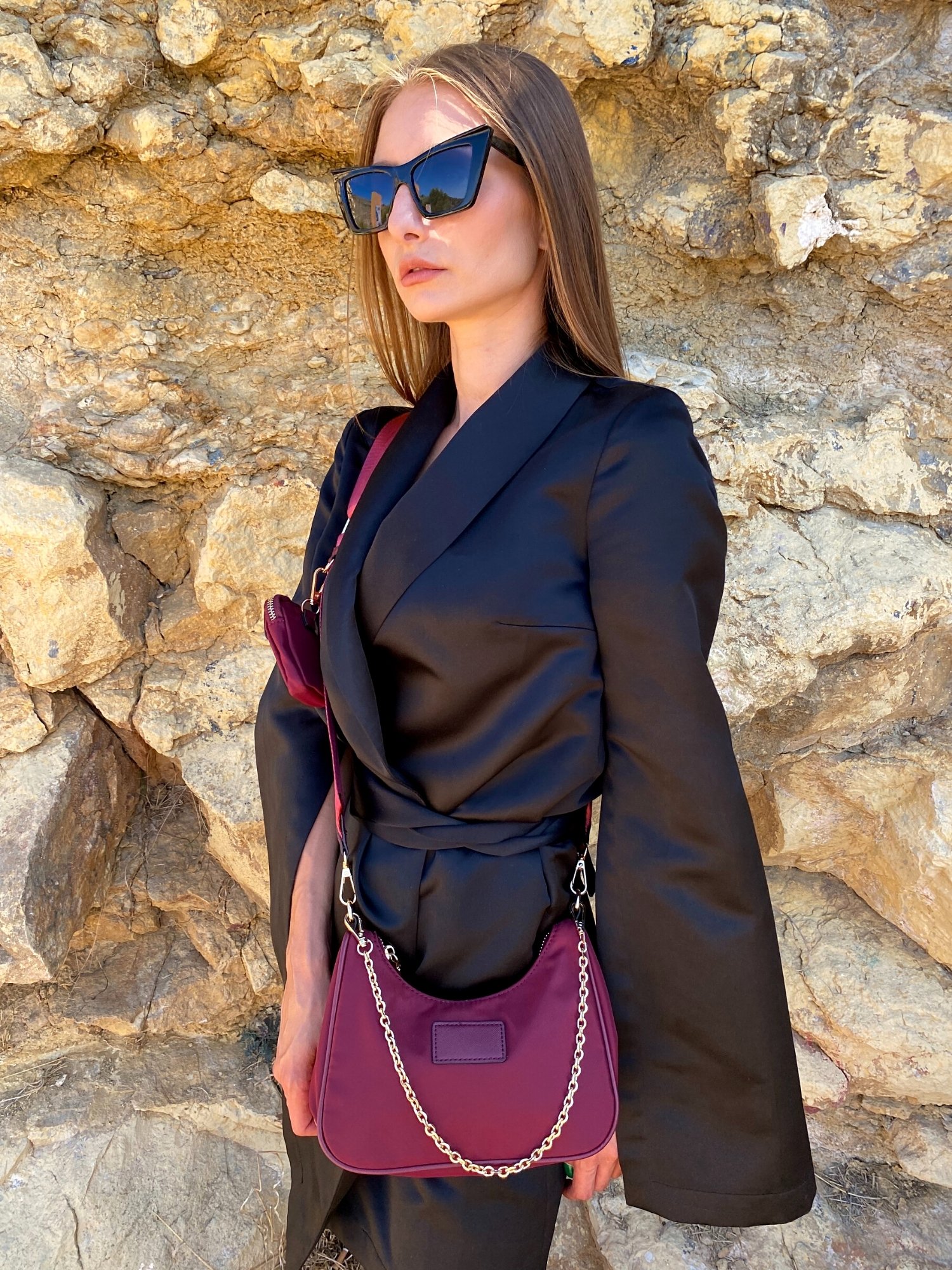 Stylish beige and magenta shoulder bag with chain, featuring adjustable strap and zip closure.