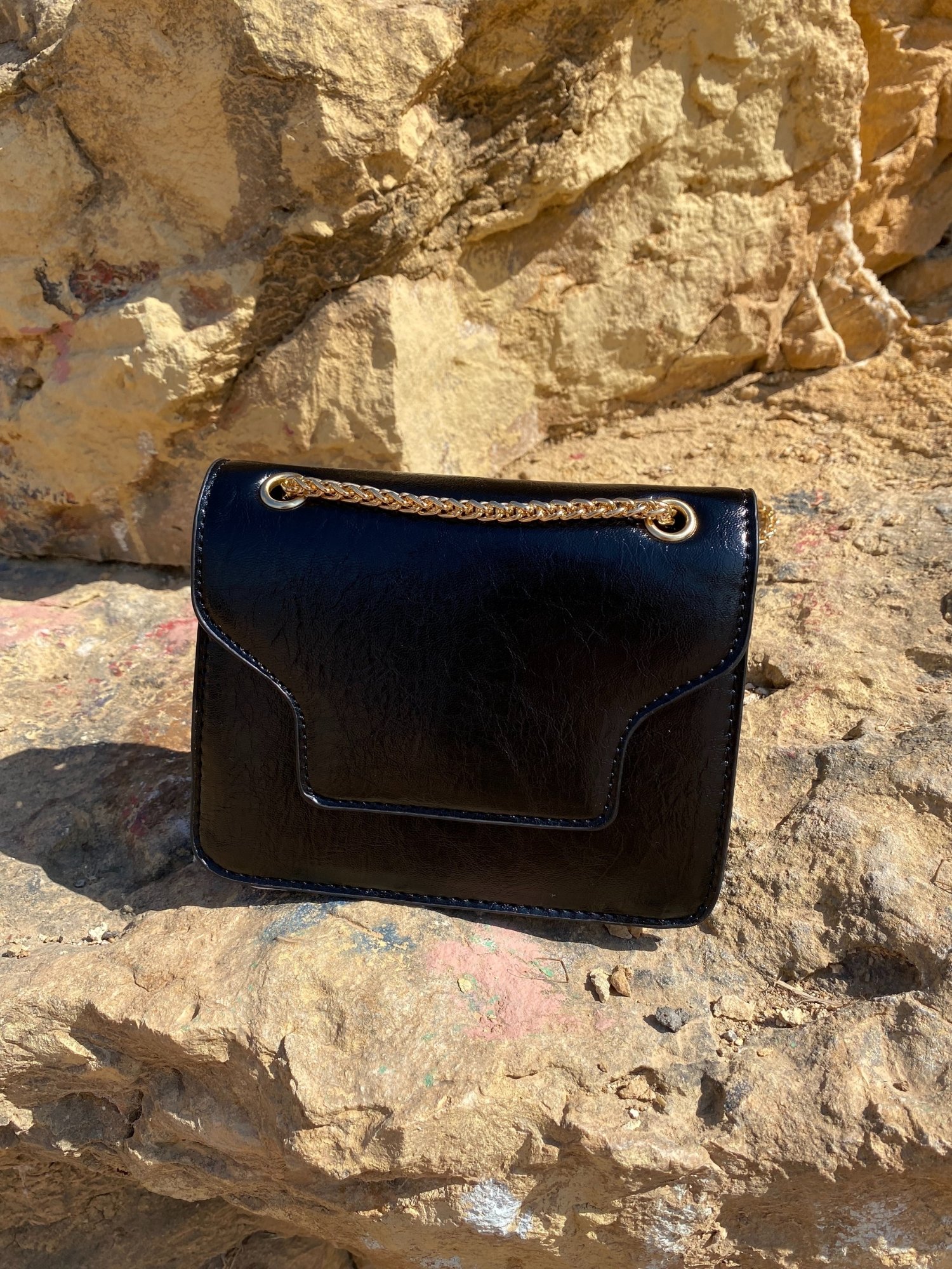 A stylish black Shoulder Mini Bag made of synthetic leather with a chain-link shoulder strap and magnetic closure.