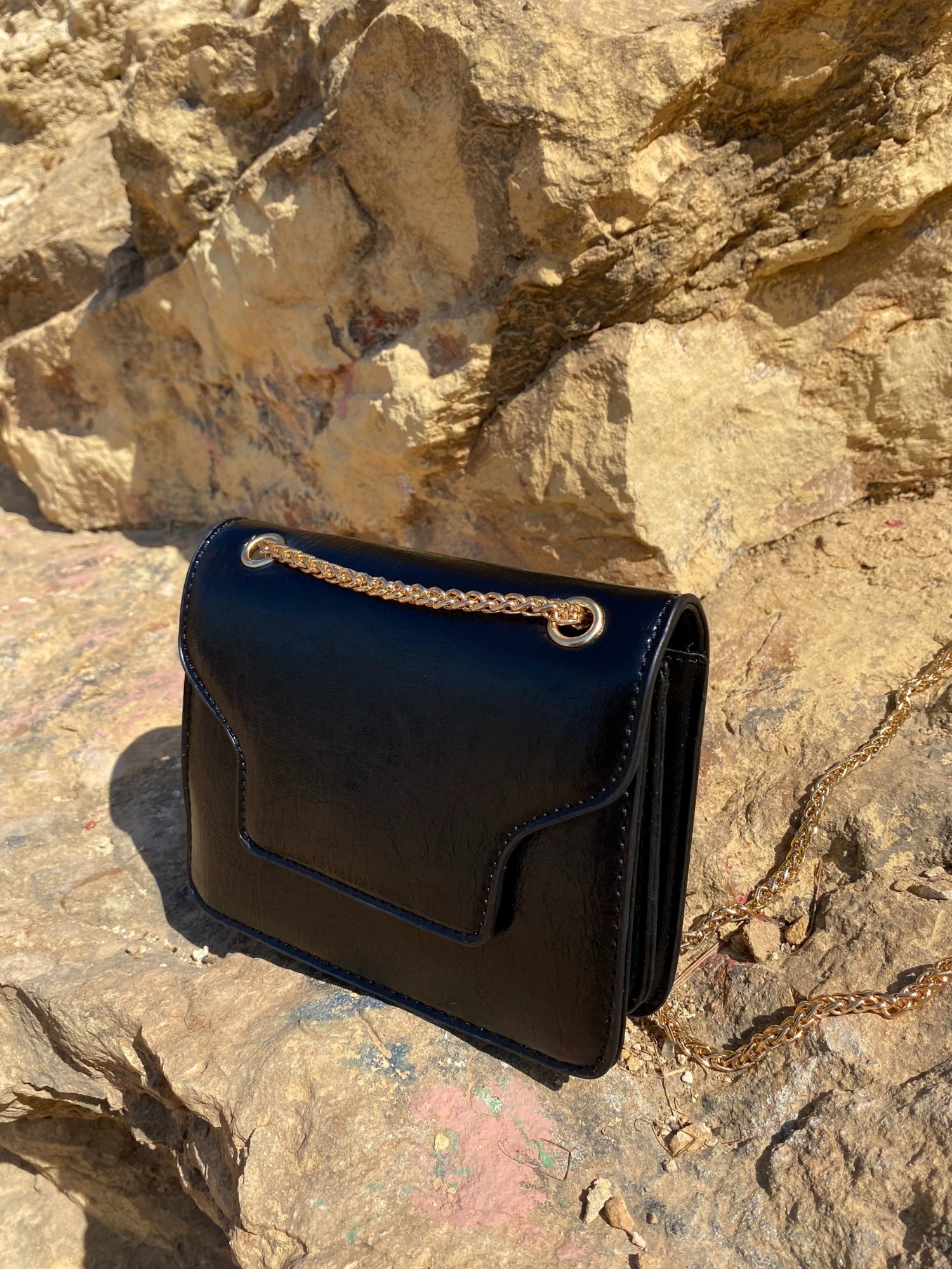 A stylish black Shoulder Mini Bag made of synthetic leather with a chain-link shoulder strap and magnetic closure.